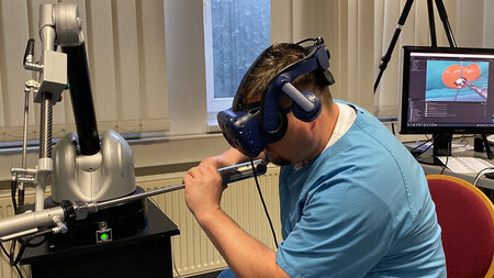 A man wears VR glasses and interacts with a technical device with his hands.